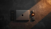 Laptop, perfume, earbuds and passport flat lay for UAE to Pakistan customs duty-free travel guide