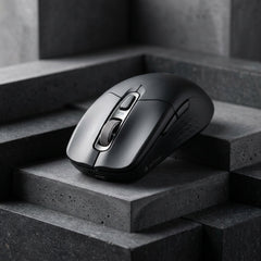 Ergonomic matte black wireless computer mouse with a metallic scroll wheel branding labeled AETHER, displayed on stacked dark gray concrete blocks.