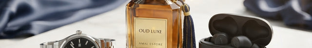 Amal Estore luxury lifestyle products featuring Oud Luxe perfume, a silver watch, and black wireless earbuds